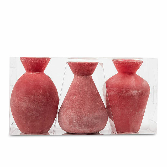 Drei rote, flaschenförmige Kerzen in verschiedenen Formen und Größen stehen nebeneinander innerhalb einer transparenten Plastikverpackung. Die Kerzen haben eine rustikale, matte Oberfläche, die ihnen ein handgefertigtes Aussehen verleiht.