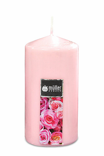 Eine rosafarbene Stumpenkerze vom Hersteller Müller. Die Kerze hat einen runden Aufkleber mit dem Logo von Müller und einem Motiv von rosafarbenen Rosen.