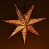 Ein leuchtender, siebenstrahliger Papierstern in warmen, goldenen Orangetönen hängt vor einem dunkelbraunen Hintergrund. Die feine Struktur des Papiers lässt das Licht weich durchscheinen und erzeugt eine beruhigende, warme Atmosphäre.