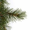 Ein dichter Ast eines künstlichen Tannenbaums mit feinen grünen Nadeln, die sich detailliert und realistisch vom weißen Hintergrund abheben. Einige der Nadeln haben kleine braune Akzente, die dem Ast ein natürliches Aussehen verleihen.