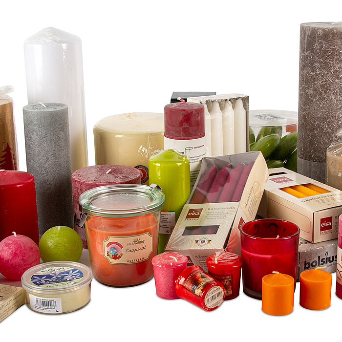 Das Bild zeigt eine vielfältige Sammlung an Kerzen und kerzenartigen Artikeln in verschiedenen Formen, Größen und Farben. Es gibt Stumpenkerzen in Farben wie Rot, Türkis, Grau, Weiß, Braun, Rosa und Gelb. Einige Kerzen sind in Gläsern oder Dosen, während 