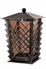 Ein dekoratives, schwarzes Metall-Laternengehäuse mit einem Gitterdesign. Die Laterne hat eine gezackte, diagonale Streifenverzierung an den Ecken und einen spitzen Deckel mit einer kleinen, runden Kugel an der Spitze. Die Seiten bestehen aus transparente