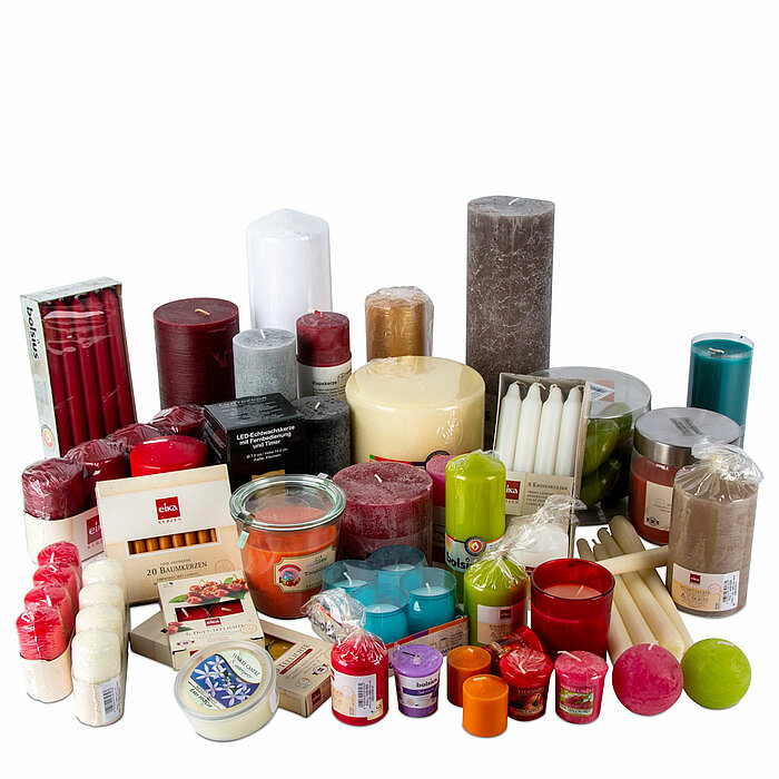 Eine vielseitige Auswahl an verschiedenen Kerzen in unterschiedlichen Farben, Formen und Größen ist auf dem Bild zu sehen. Die Kollektion umfasst große Stumpenkerzen in Weiß, Rot, Braun, Grau und Blau, kleinere Stumpenkerzen in Rot und Weiß sowie bunte Te