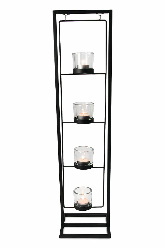 Vier brennende Teelichter, jedes in einem transparenten Glasbehälter, sind in einem vertikalen schwarzen Metallrahmen angeordnet. Der Rahmen ist rechteckig und steht stabil auf einer rechteckigen Basis. Die Teelichter sind gleichmäßig auf vier Ebenen im R