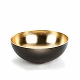 Eine stilvolle Schale mit einer glänzenden goldenen Innenseite und einer mattschwarzen Außenseite. Die Schale hat eine runde Form und steht auf einer weißen Oberfläche.