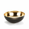 Eine stilvolle Schale mit einer glänzenden goldenen Innenseite und einer mattschwarzen Außenseite. Die Schale hat eine runde Form und steht auf einer weißen Oberfläche.