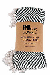 Eine zusammengerollte Decke aus der "Mood Collection". Sie besteht zu 100% aus recycelter Baumwolle und hat die Maße 130 x 170 cm. Das Muster der Decke zeigt ein schwarzes und weißes Fischgrätenmuster. Die Enden der Decke sind mit weißen Fransen versehen.