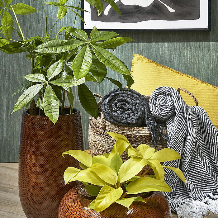 Ein eleganter grauer Teppich mit feiner Fischgrätenmusterung und weißen Fransen an den beiden schmalen Seiten. Die schlichte, aber stilvolle Gestaltung vermittelt ein Gefühl von Ruhe und zeitloser Eleganz.