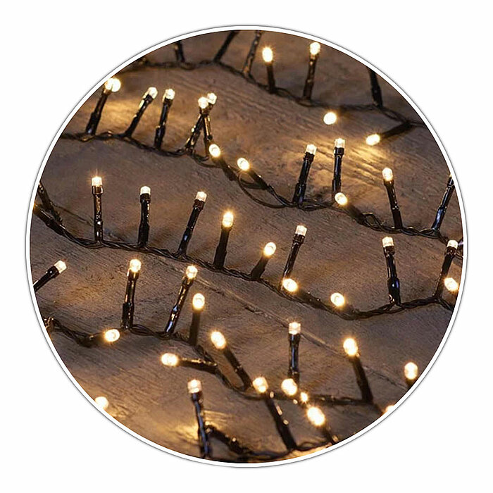 Viele kleine, warmweiße Lichter einer Lichterkette leuchten in einem wellenförmigen Muster auf dunklem Hintergrund. Die Lichter sind gleichmäßig verteilt und erzeugen ein sanftes, gemütliches Leuchten.
