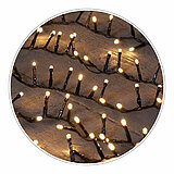 Viele kleine, warmweiße Lichter einer Lichterkette leuchten in einem wellenförmigen Muster auf dunklem Hintergrund. Die Lichter sind gleichmäßig verteilt und erzeugen ein sanftes, gemütliches Leuchten.