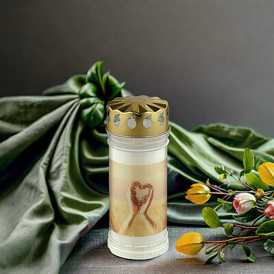 Eine Motiv-Grabkerze mit goldenem Blechdeckel steht neben einem Strauß Blumen vor einem grünen Tuch.