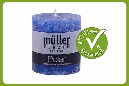 Eine Rustik Stumpenkerze von Müller Kerzenfabrik in der Größe 75/68 mm in der Farbe Delft ist auf dem Bild zu sehen. Neben der Kerze ist ein grüner Kerzenprofi getestet Button. Der Rest des Bildes ist weiss.