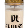 Eine weiße Gedenkkerze mit schwarzer Aufschrift "DU FEHLST" auf der Vorderseite. Die Kerze hat einen goldfarbenen Deckel mit mehreren kleinen Öffnungen.