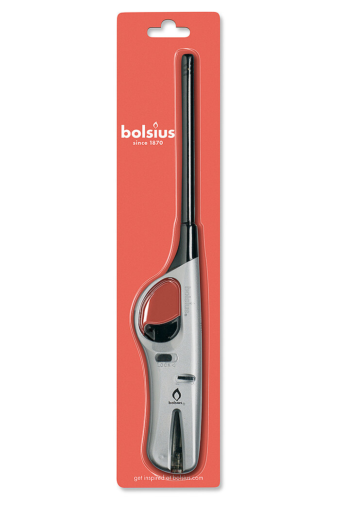 Eine silberfarbene Bolsius Feuerzeug in länglicher Form, verpackt auf einer roten Kartonrückwand mit einem Aufhängeloch oben. Auf dem Karton ist das Bolsius-Logo sowie der Schriftzug "bolsius since 1870" in Weiß zu sehen. Das Feuerzeug hat einen ergonomis