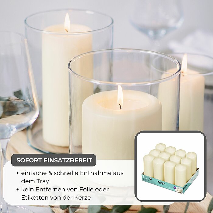 Sechs brennende Stumpenkerzen in Glaszylindern stehen in einer Reihe auf einem rustikalen Holzbodenbrett in der Mitte eines gedeckten Tisches. Die Kerzen werden von Trockenblumen und Gräsern umgeben. Um den Tisch herum sind weiße Teller mit gelben Stoffse